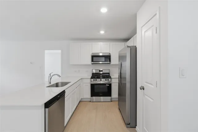 a kitchen with granite countertop white cabinets and stainless steel appliances