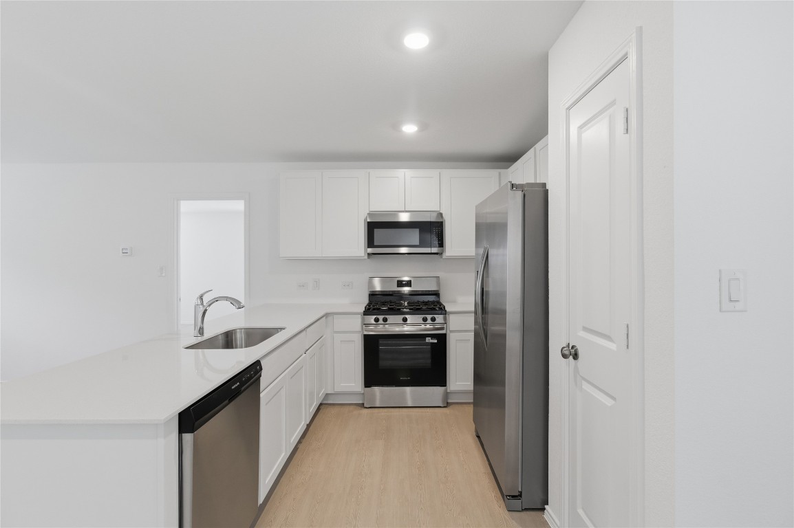 596 Sormonne Loop Kyle, TX 78640 - Photo 5 of 25 a kitchen with stainless steel appliances granite countertop white cabinets and refrigerator