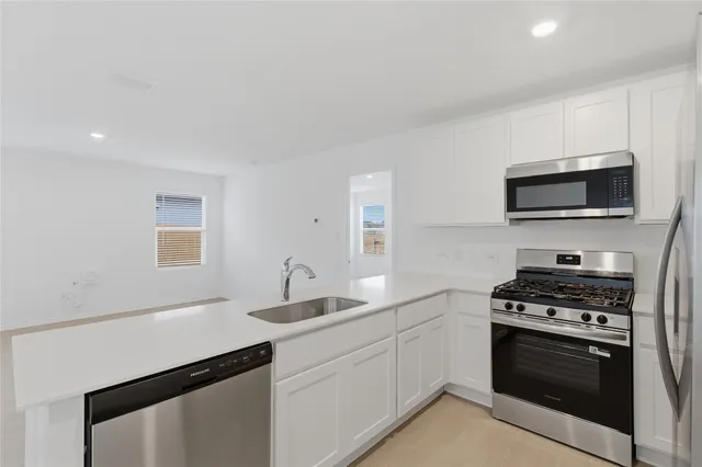 a kitchen with stainless steel appliances granite countertop white cabinets and refrigerator