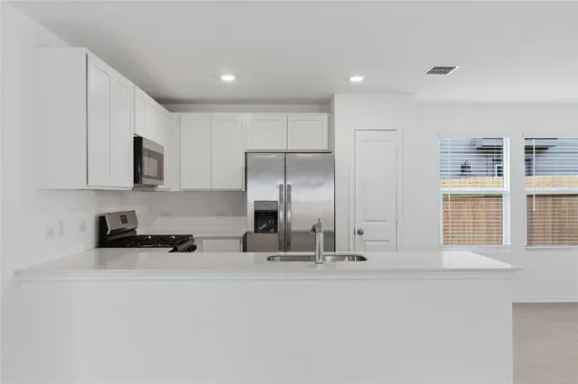 a kitchen with stainless steel appliances a stove sink and microwave