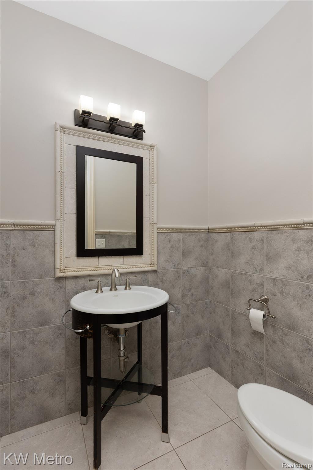 65884 Windrose Court Ray, MI 48096 - Photo 57 of 82 Half bathroom featuring tile walls, a wainscoted wall, and light tile patterned floors