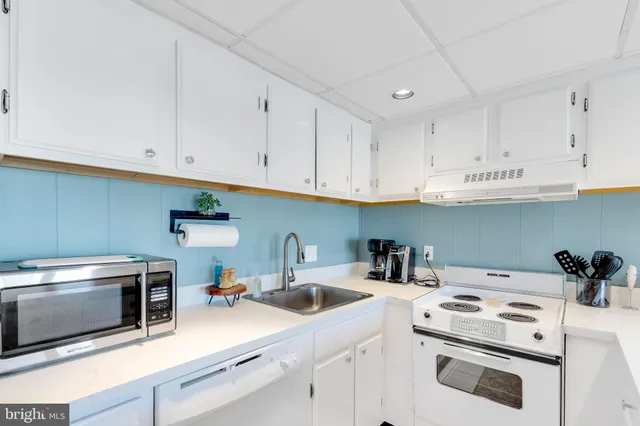 a kitchen with a sink a stove and cabinets