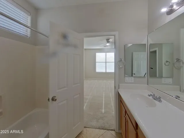 an empty room with a window and a fan