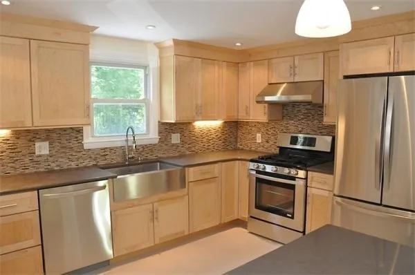 a kitchen with granite countertop white cabinets white stainless steel appliances and a sink