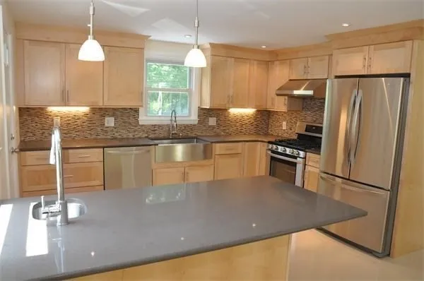 a kitchen with stainless steel appliances granite countertop a sink refrigerator and microwave