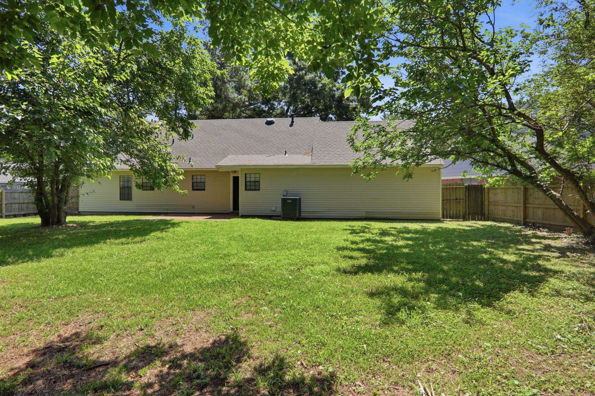 3113 Raleigh Ridge Cove Memphis, TN 38128 - Photo 37 of 38 Spacious backyard featuring a manicured lawn, established trees, and a privacy fence