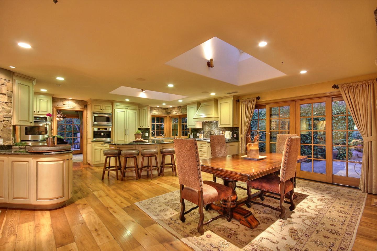 15668 Bohlman Road Saratoga, CA 95070 - Photo 12 of 33 a dining room with stainless steel appliances kitchen island granite countertop a table and chairs