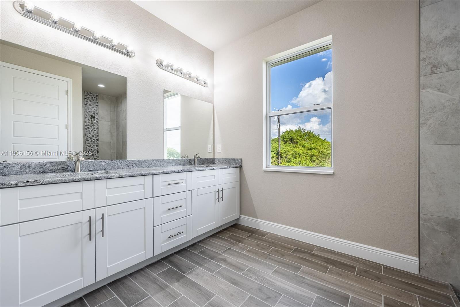 626 Royce Road LaBelle, FL 33935 - Photo 24 of 40 a bathroom with a granite countertop sink and a mirror