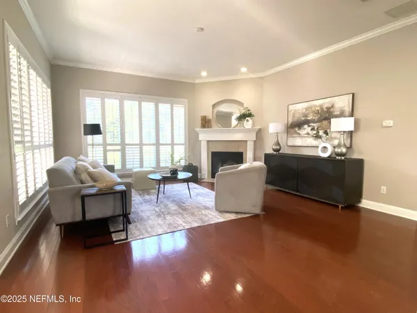 a living room with furniture a fireplace and a floor to ceiling window