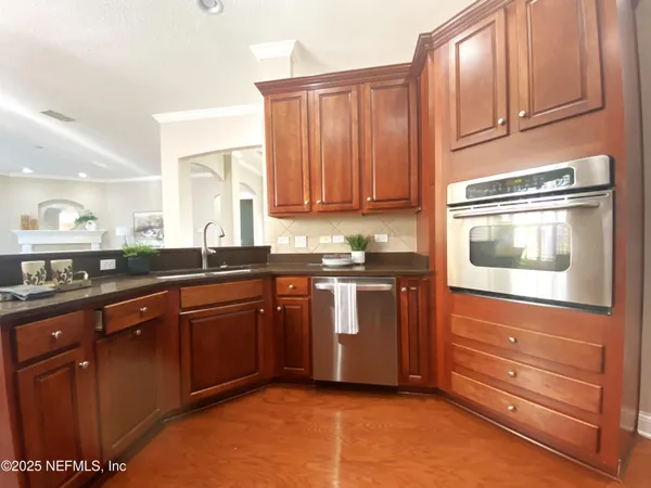 a kitchen with granite countertop wooden cabinets and stainless steel appliances