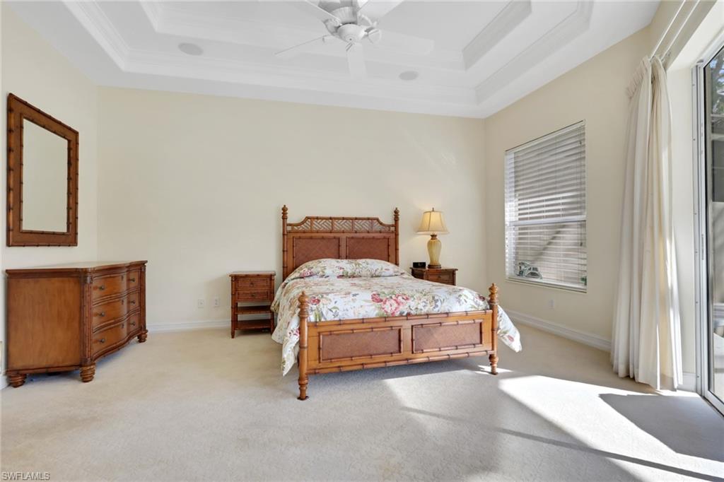 3134 Santorini Court Naples, FL 34119 - Photo 14 of 21 a bedroom with a bed and a chandelier