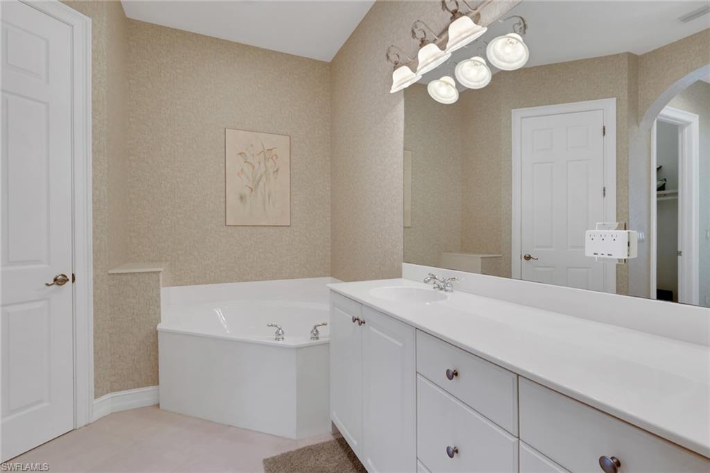 3134 Santorini Court Naples, FL 34119 - Photo 18 of 21 a bathroom with a sink vanity and a mirror