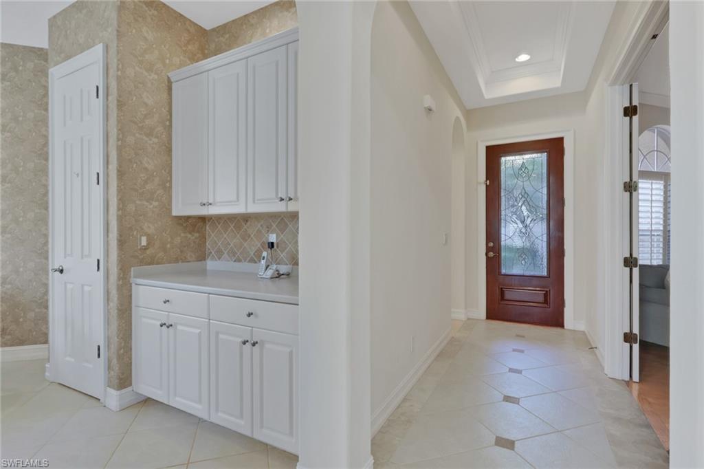 3134 Santorini Court Naples, FL 34119 - Photo 2 of 21 a spacious bathroom with a granite countertop sink a mirror and a vanity