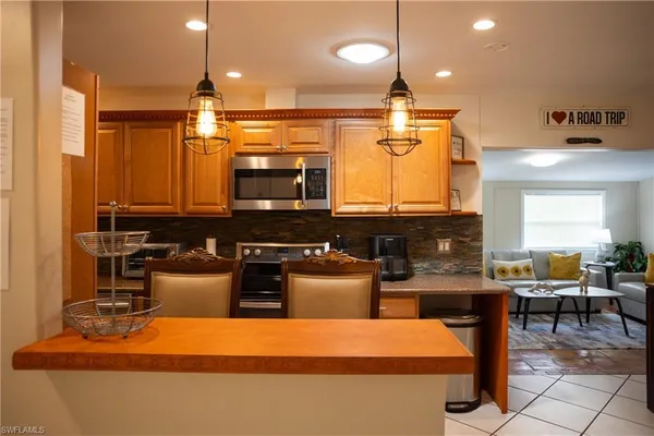 a kitchen with stainless steel appliances kitchen island granite countertop a sink and a stove