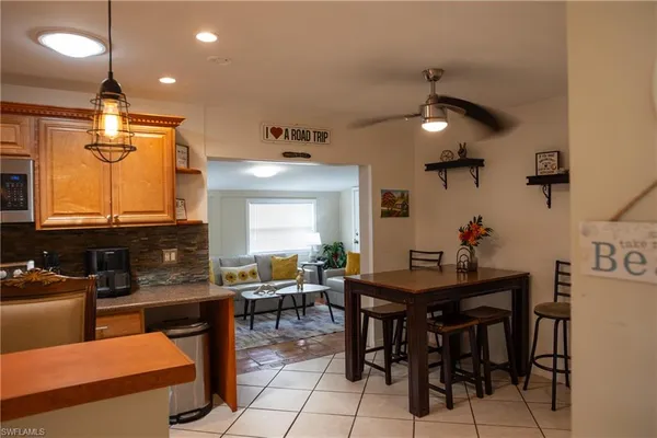 a kitchen with stainless steel appliances kitchen island granite countertop a table and chairs in it