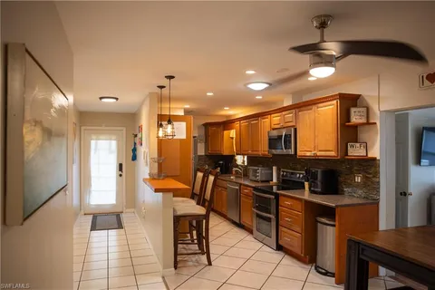 a kitchen with stainless steel appliances kitchen island granite countertop a refrigerator and a stove top oven