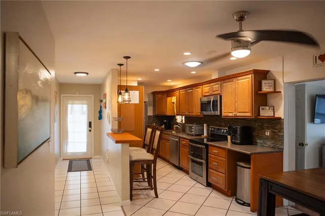 a kitchen with stainless steel appliances kitchen island granite countertop a refrigerator and a stove top oven
