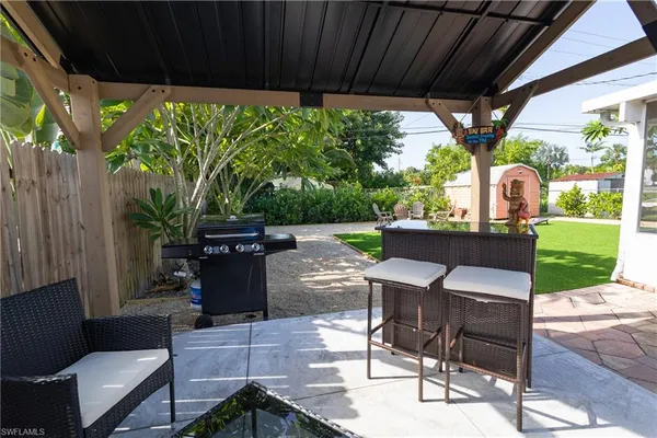 a view of a patio with table and chairs potted plants with floor to ceiling window plants and garden view