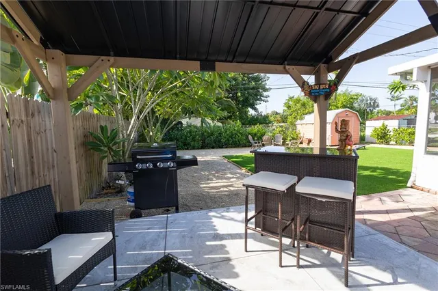 a view of a patio with table and chairs potted plants with floor to ceiling window plants and garden view