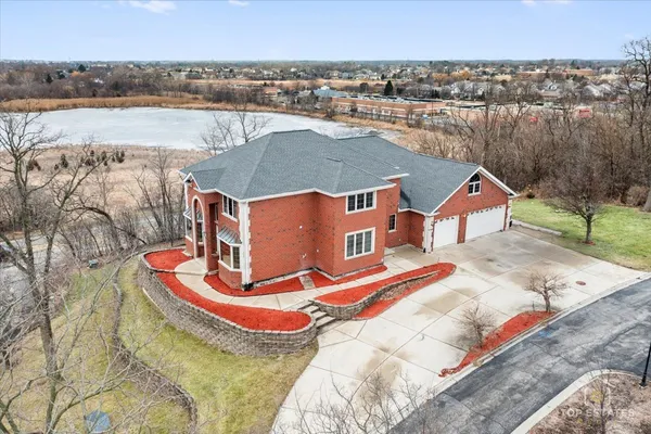 an aerial view of a house with outdoor space and lake view