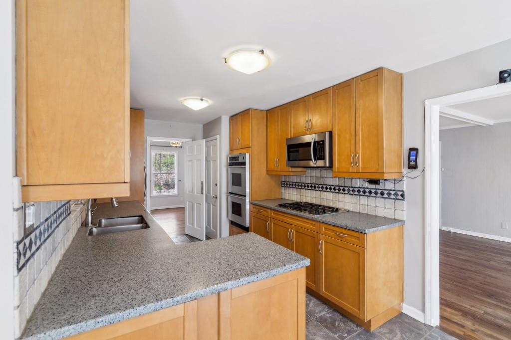 355 Westerhall Court Sandy Springs, GA 30328 - Photo 11 of 37 a kitchen with stainless steel appliances granite countertop a sink and a refrigerator