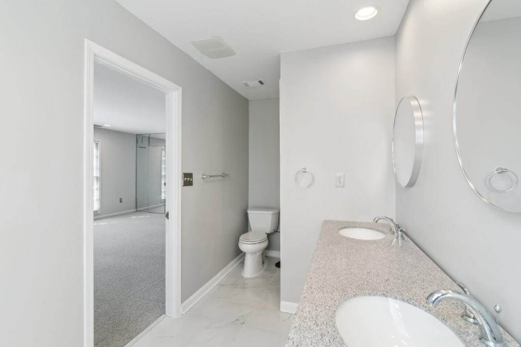 355 Westerhall Court Sandy Springs, GA 30328 - Photo 19 of 37 a bathroom with a granite countertop toilet and a sink