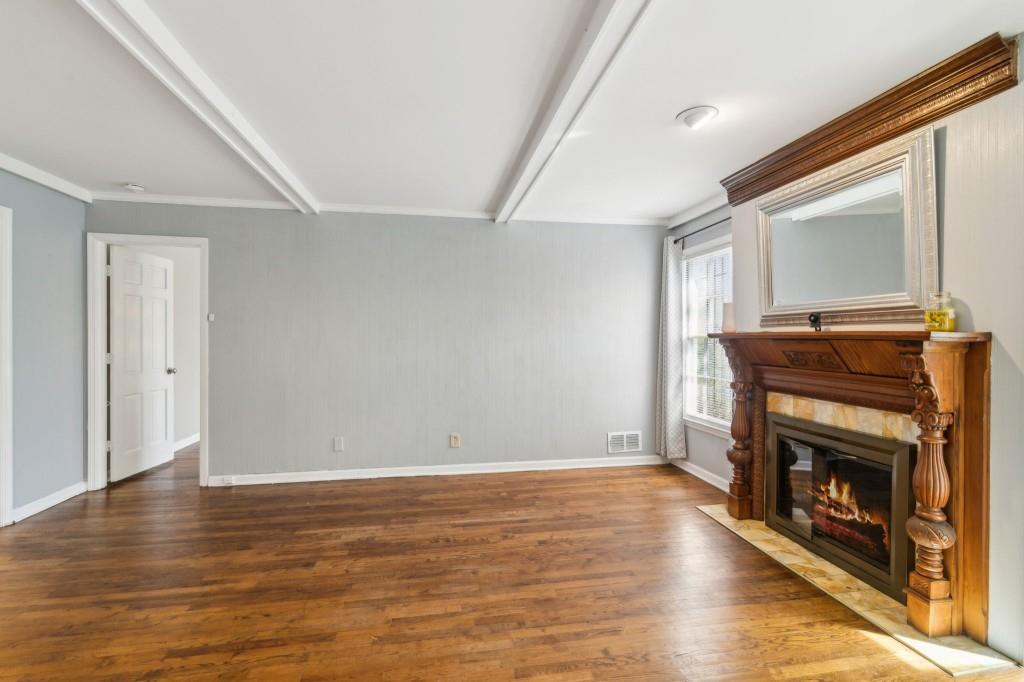 355 Westerhall Court Sandy Springs, GA 30328 - Photo 8 of 37 a view of an empty room with wooden floor fireplace and a window