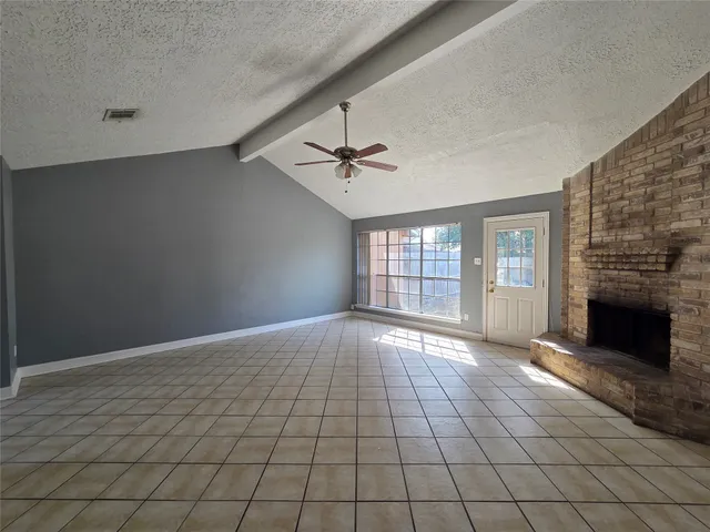 a view of an empty room with a fireplace and a window