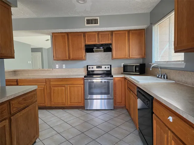 a kitchen with stainless steel appliances granite countertop a stove sink and cabinets