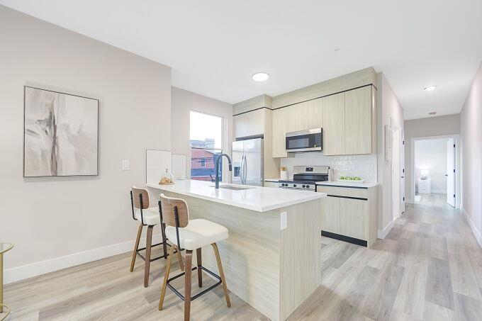 304 61st Street, Unit 1D West New York, NJ 07093 - Photo 33 of 44 a kitchen with white cabinets and stainless steel appliances