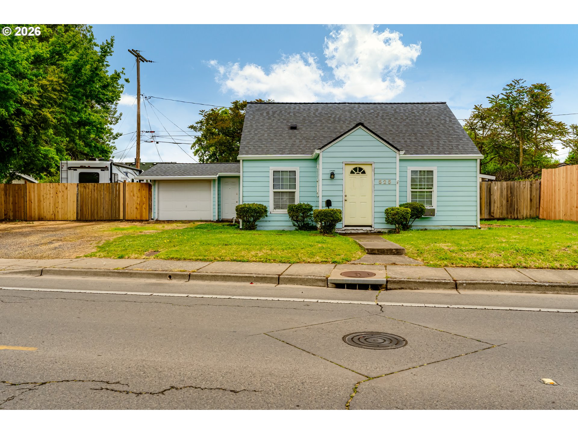 a view of a house with a yard and a large parking space