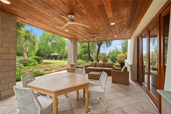 an outdoor sitting area with furniture and umbrella