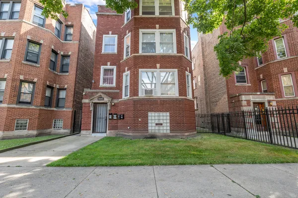 a view of a brick building next to a yard