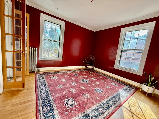 a view of entryway bedroom and hall with wooden floor