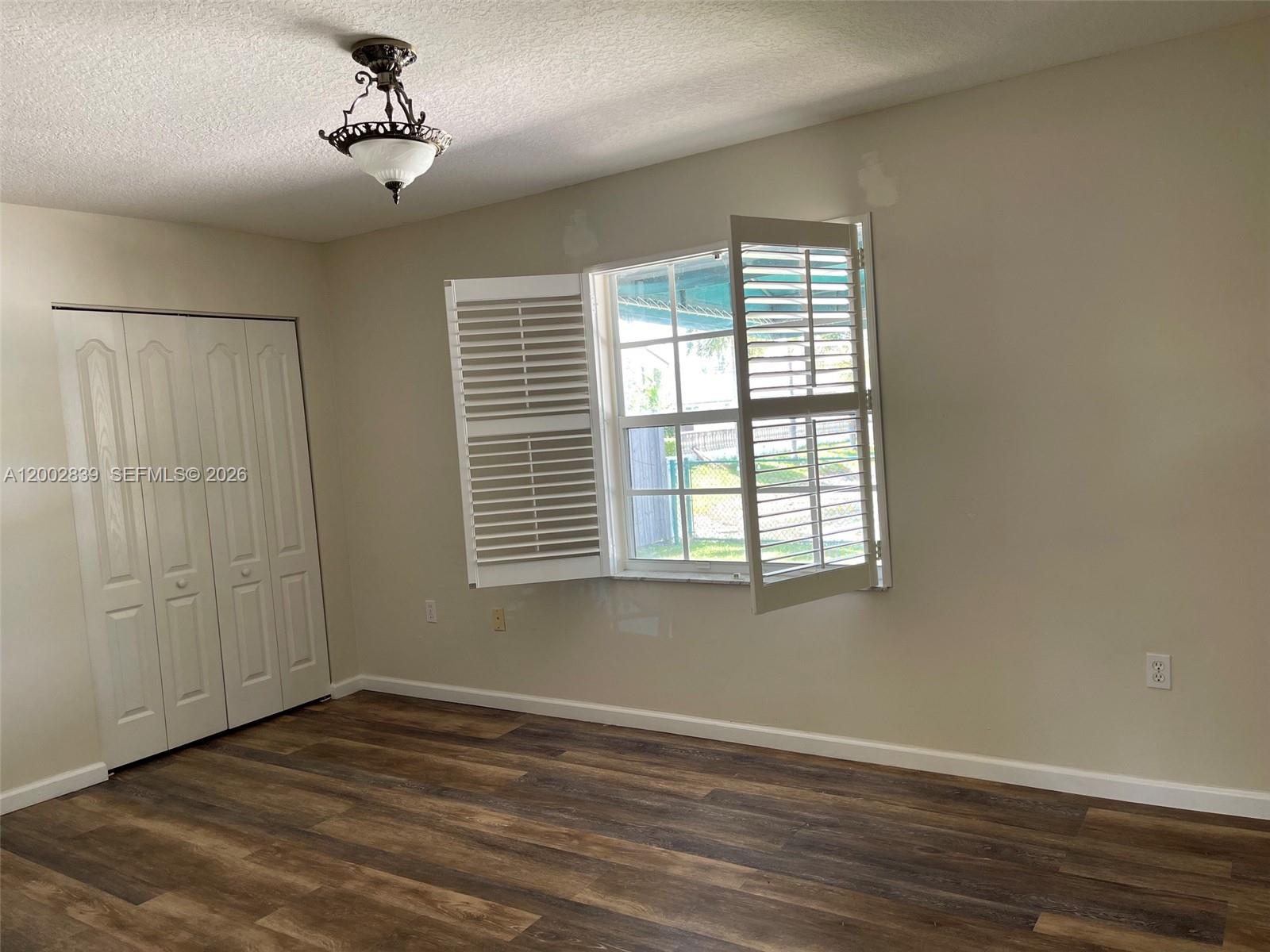 15873 Southwest 43rd Street Miami, FL 33185 - Photo 9 of 23 a view of an empty room with a window and wooden floor