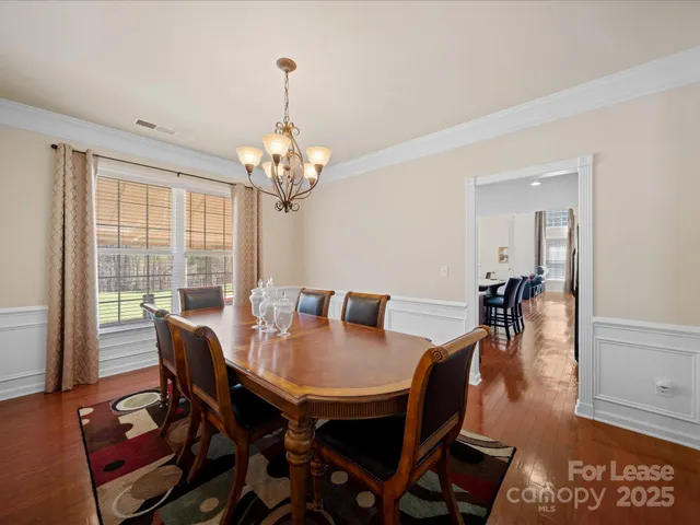 a view of a dining room with furniture wooden floor and chandelier