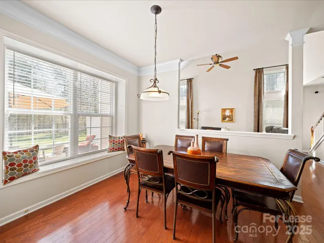 a dining room with furniture a chandelier and wooden floor