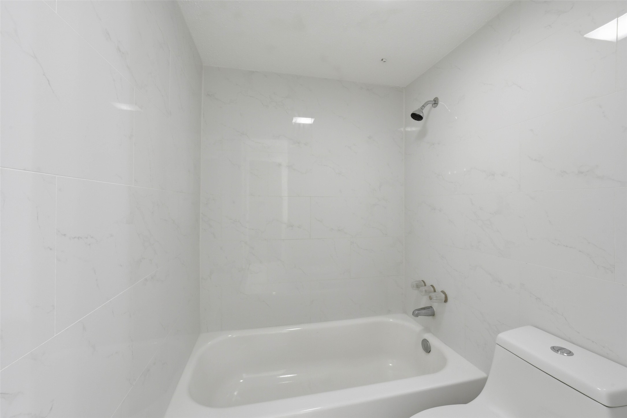 2100 Tanglewilde Street, Unit 625 Houston, TX 77063 - Photo 13 of 23 a white bath tub sitting next to a white toilet