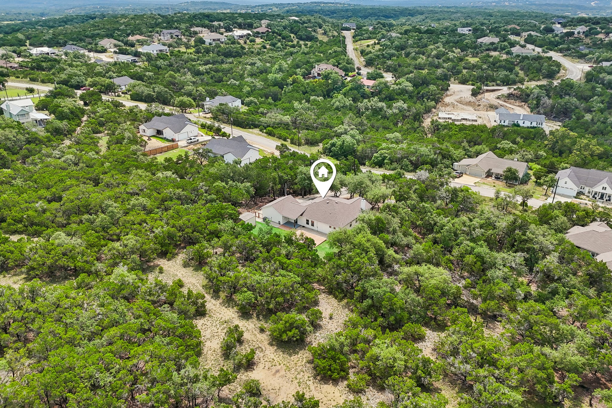 190 Magnolia Meadow Spring Branch, TX 78070 - Photo 29 of 29 An aerial perspective reveals a secluded residence nestled amidst a vibrant, tree-filled landscape with distant neighboring homes.