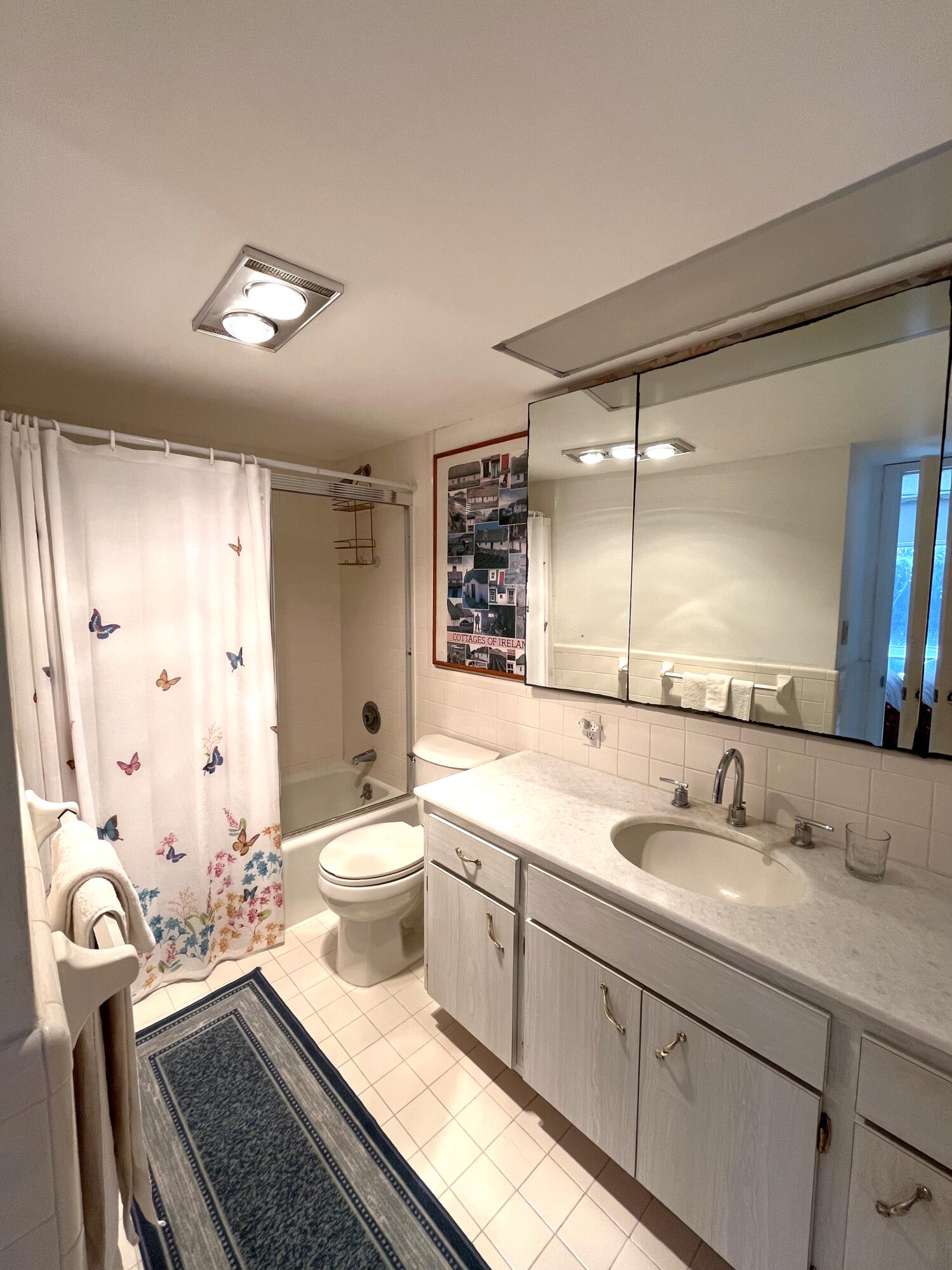 50 Celestial Way, Unit 207 Juno Beach, FL 33408 - Photo 21 of 30 a spacious bathroom with a double vanity sink a toilet a mirror and a shower