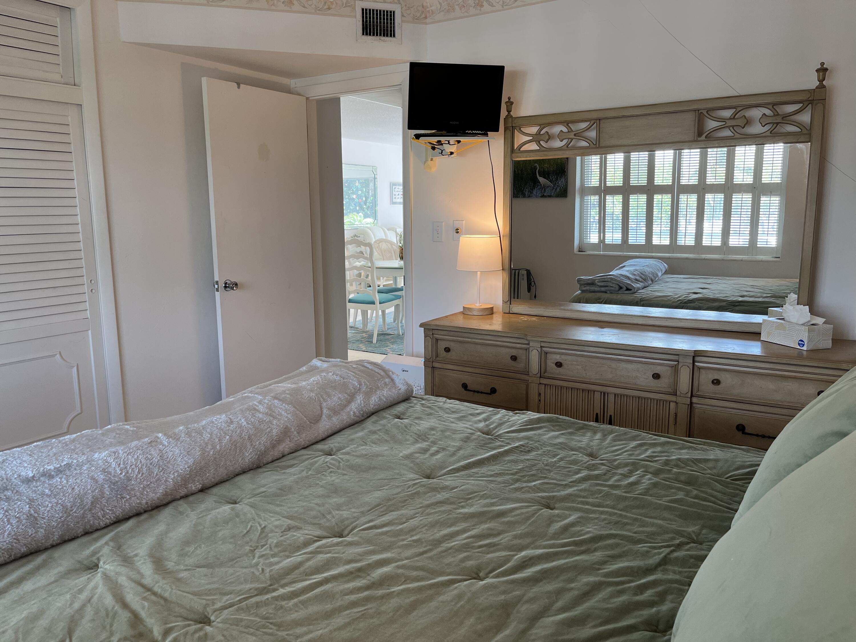 50 Celestial Way, Unit 207 Juno Beach, FL 33408 - Photo 23 of 30 a bedroom with a bed and a television