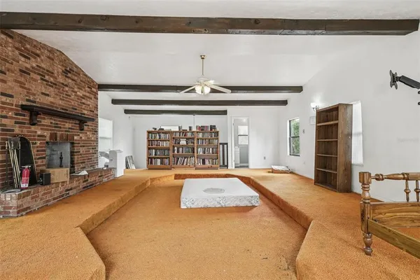 a living room with fireplace furniture and a large window