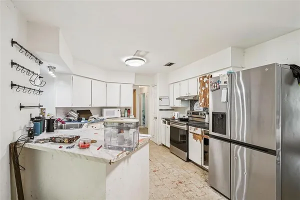 a kitchen that has a lot of cabinets a sink and appliances