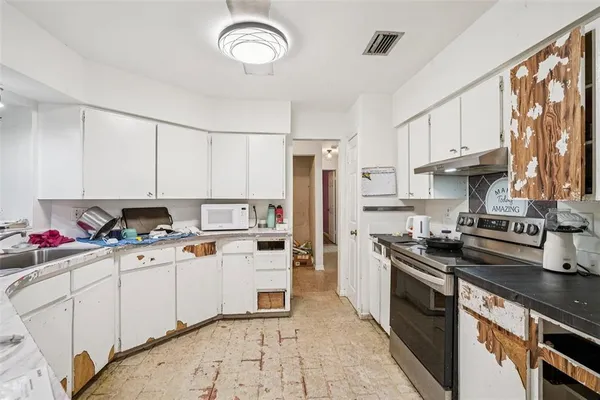 a kitchen with a sink a stove and cabinets