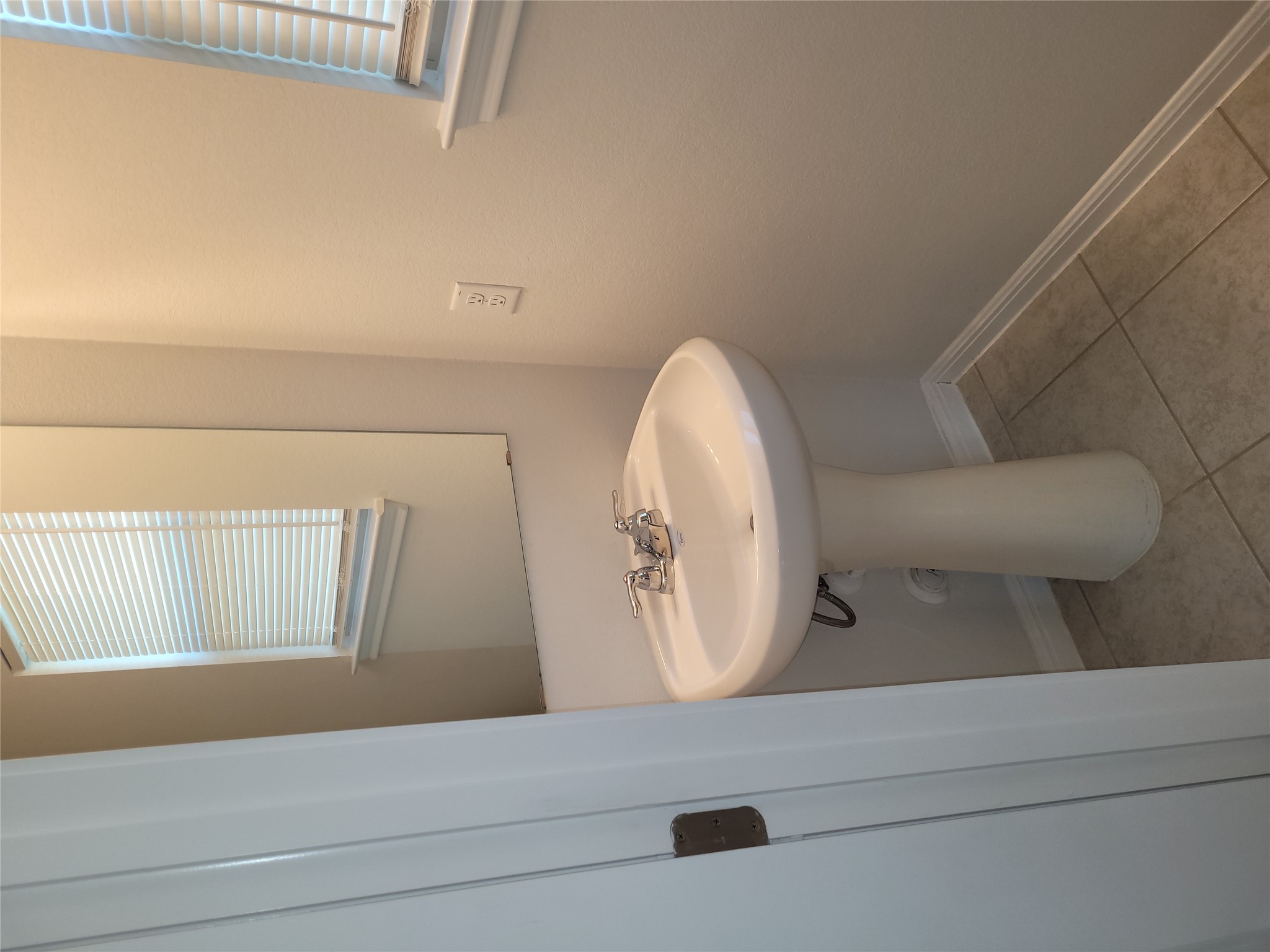 8308 Daisy Cutter Crossing Georgetown, TX 78626 - Photo 9 of 27 A compact and functional bathroom, featuring a clean pedestal sink and durable tile flooring.
