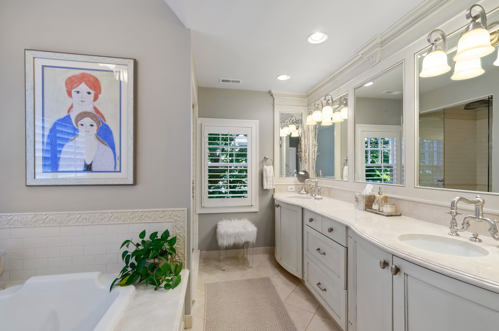 672 Elder Lane Winnetka, IL 60093 - Photo 20 of 32 a spacious bathroom with a granite countertop sink a large mirror and a bathtub next to a window