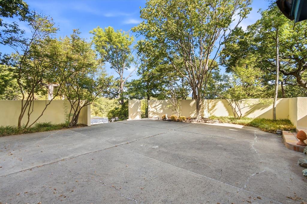 3606 Labrador Grapevine, TX 76051 - Photo 6 of 38 Expansive paved driveway bordered by mature trees and a stucco wall