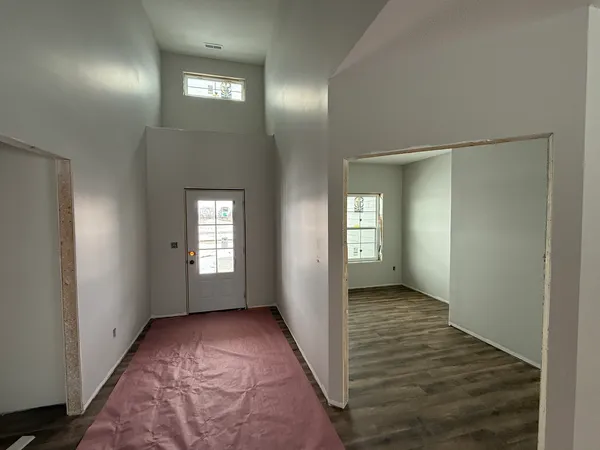 a view of hallway with window and wooden floor