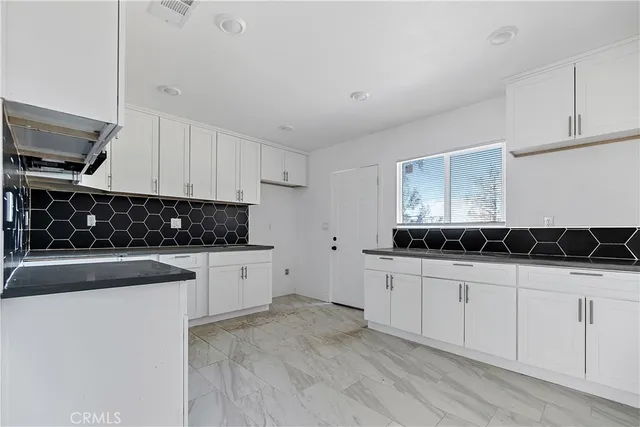 a kitchen with granite countertop a sink and a stove