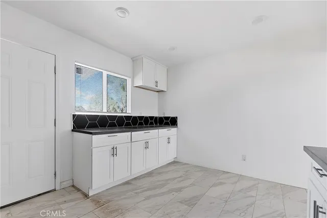 a kitchen with white cabinets sink and stainless steel appliances